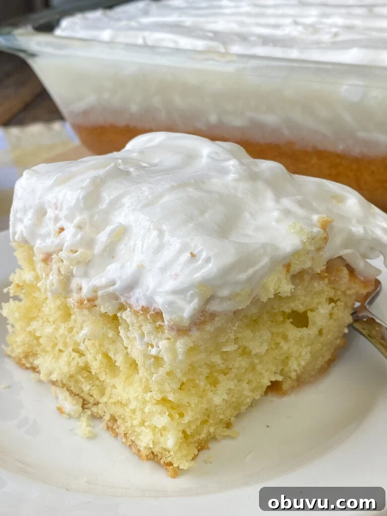 Moist piece of yellow cake with a generous topping of sour cream and coconut to make it extra moist
