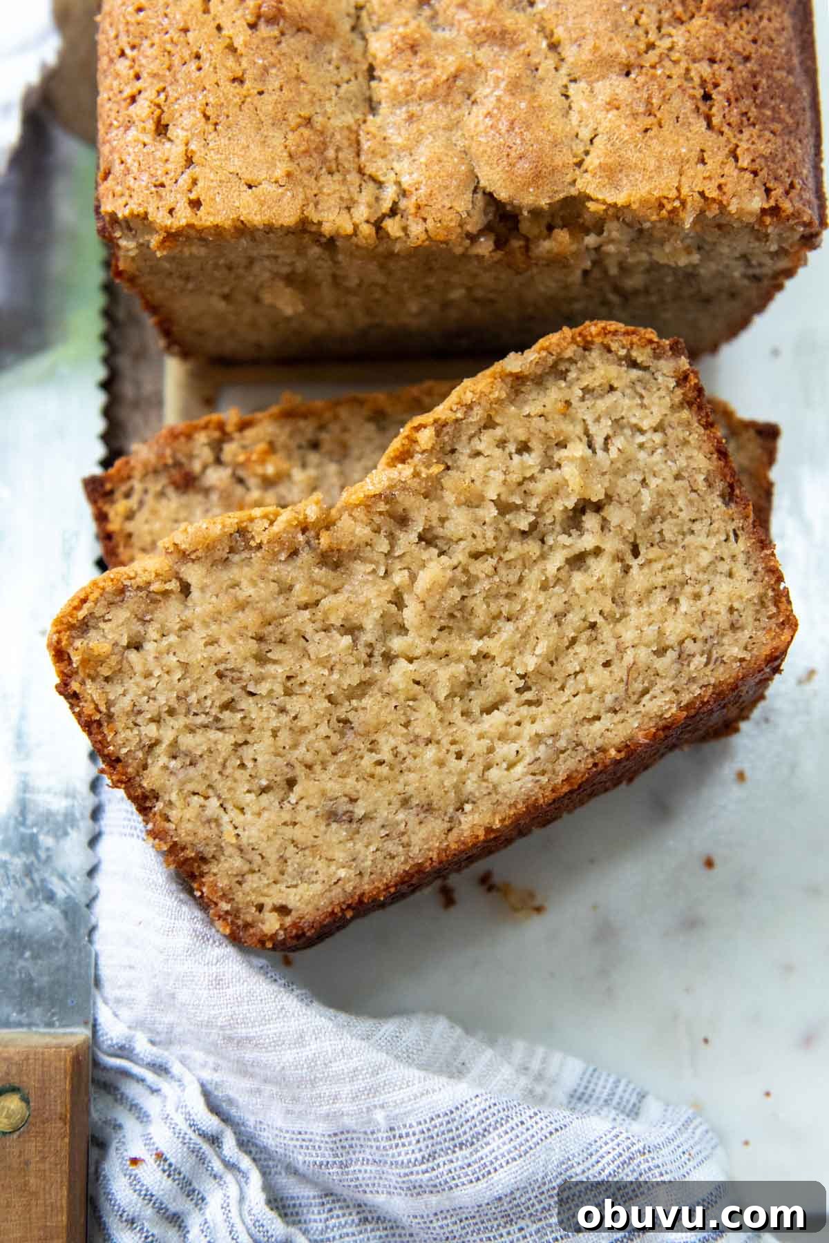 Moist Almond Flour Banana Bread Made with Oil 2 sliced almond flour bread face up on a white marble board.