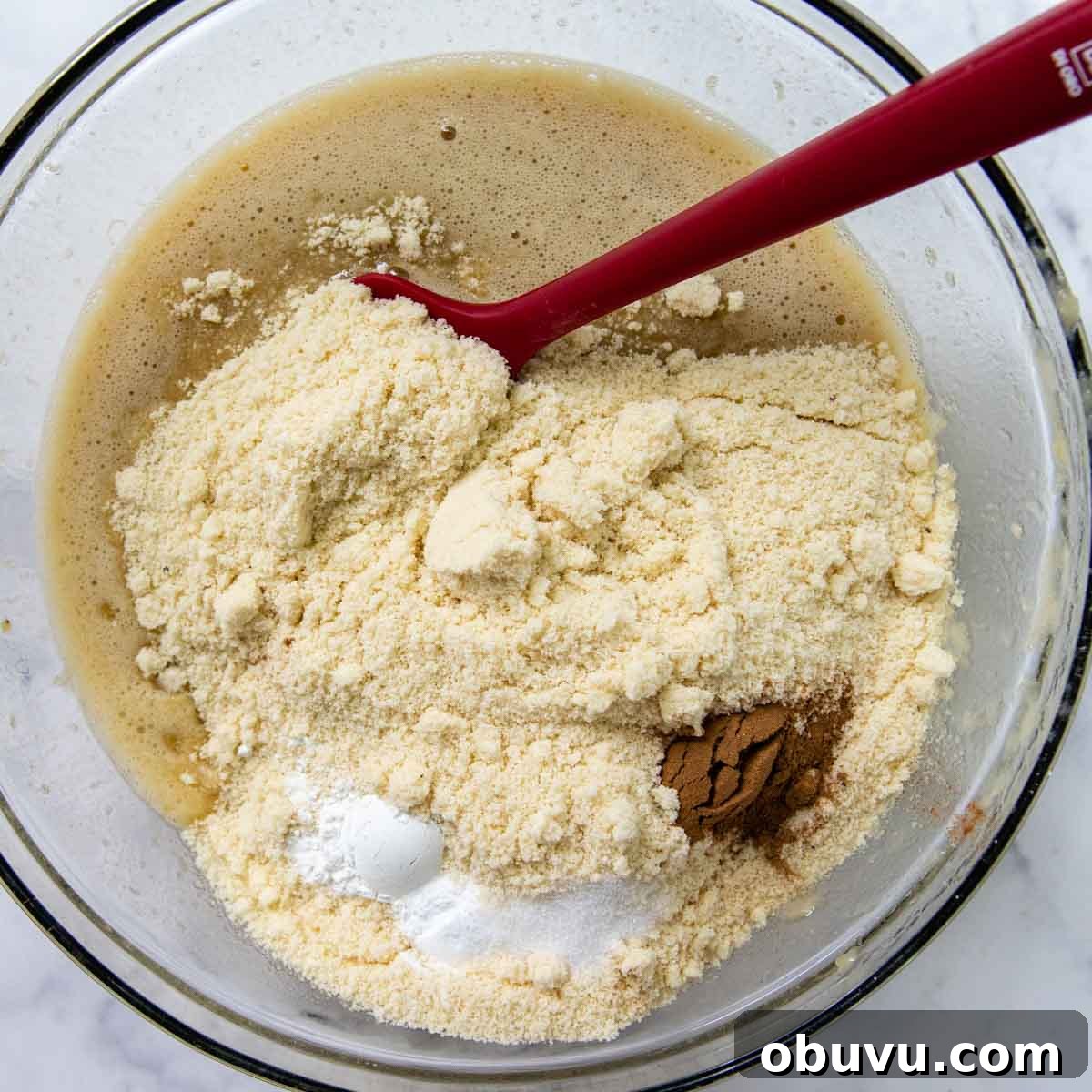 Moist Almond Flour Banana Bread Made with Oil 4 dry ingredients mixed in the bowl with the mashed bananas.