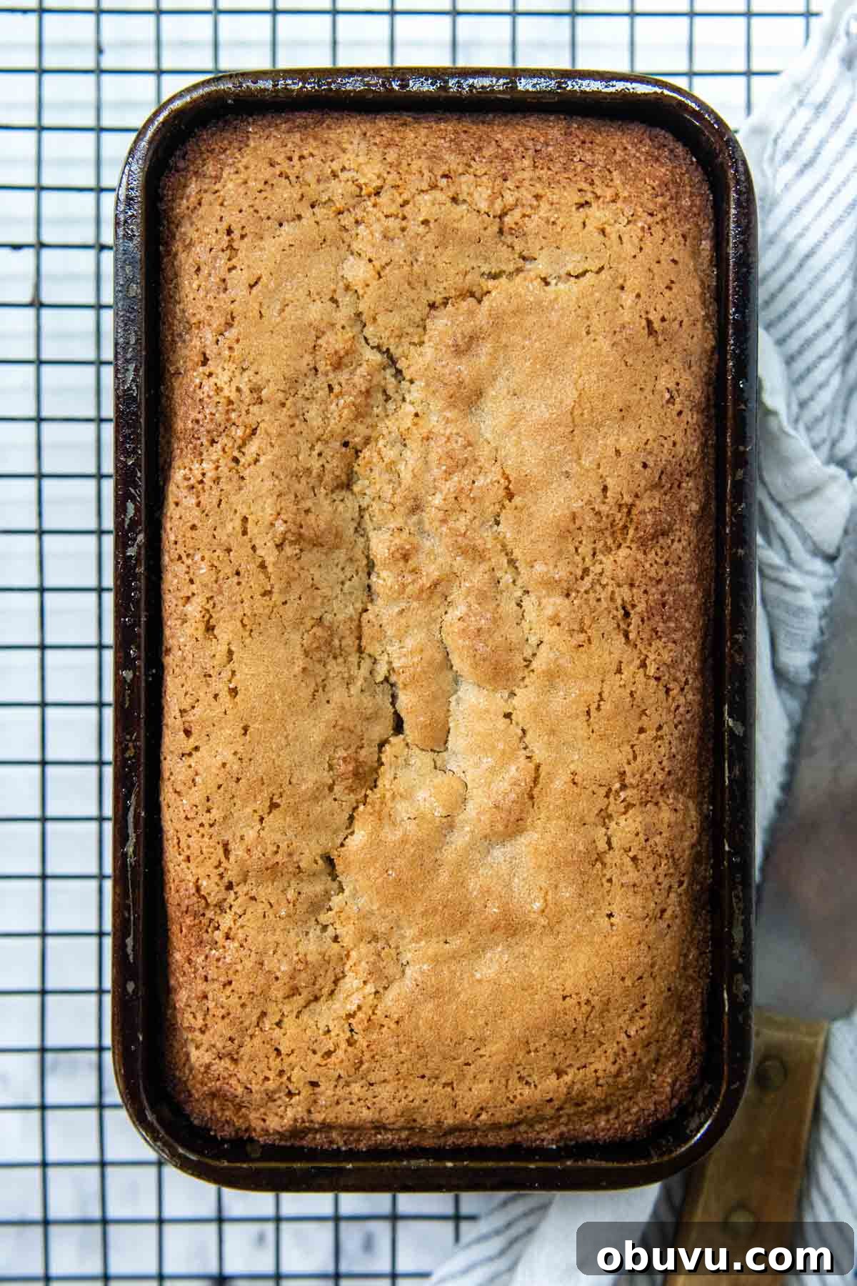 Moist Almond Flour Banana Bread Made with Oil 6 overhead shot of banana bread in a loaf pan on a wire rack.