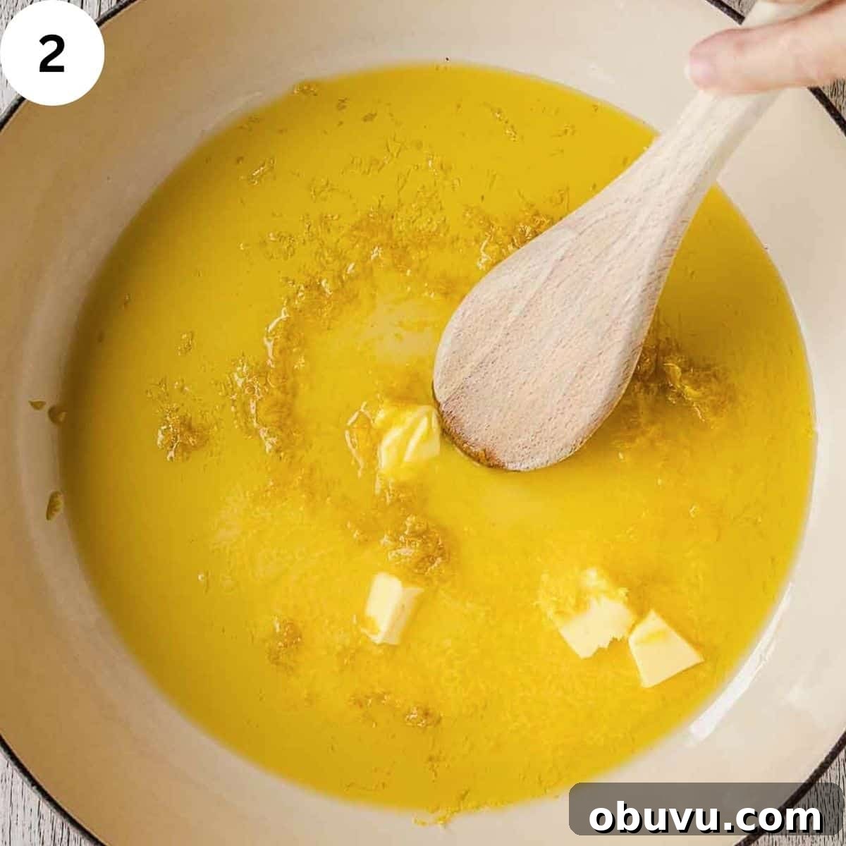 Stirring butter, olive oil and grated lemon zest in a pan.