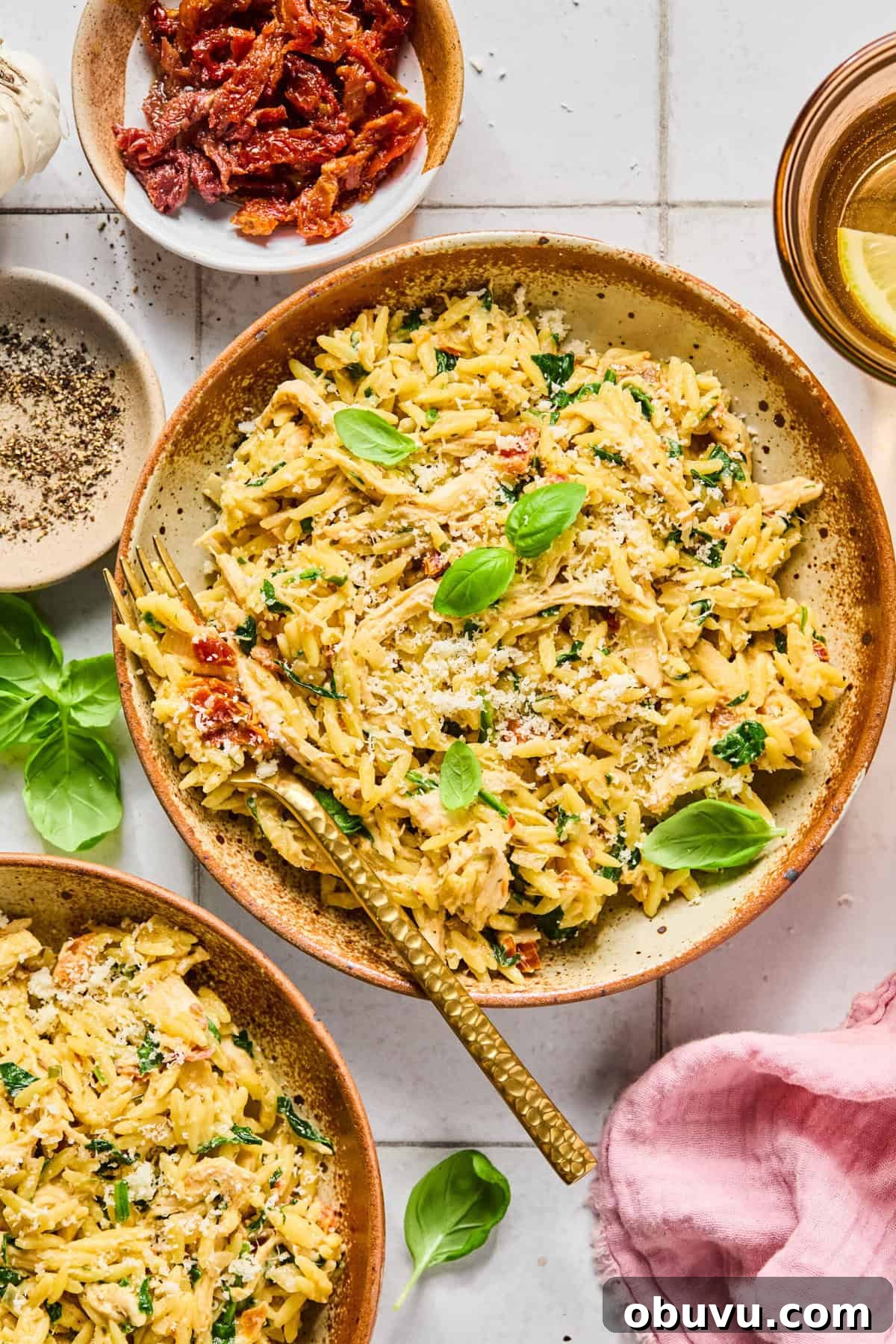 Gluten-Free Marry Me Chicken with Creamy Orzo 9 Birds eye view of creamy gluten-free marry me chicken orzo topped with fresh basil and grated parmesan in a bowl.