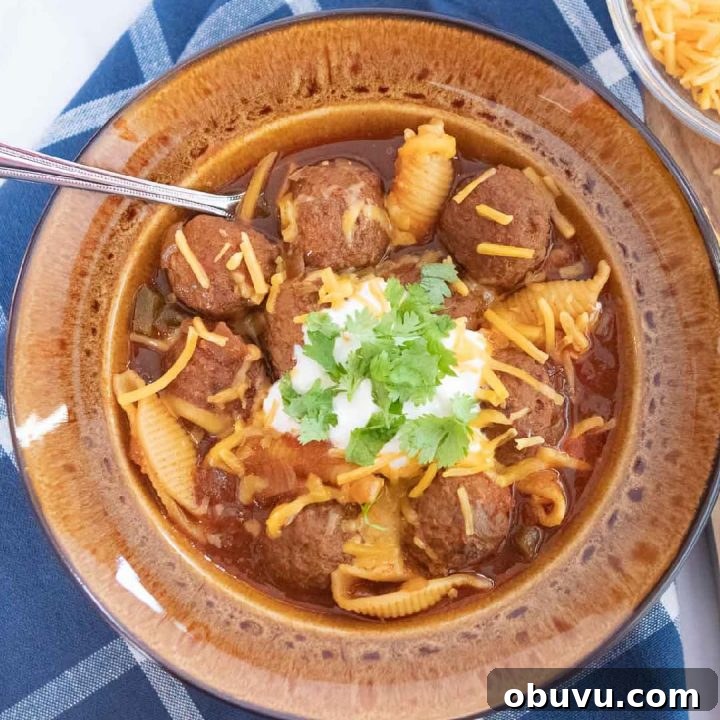 Week 13 Meal Plan: Group 2 Weekly Menu & Grocery List 5 Overhead shot of albondigas soup (Mexican meatball soup) in a brown wide-rim bowl garnished with sour cream, grated cheddar cheese, and fresh cilantro