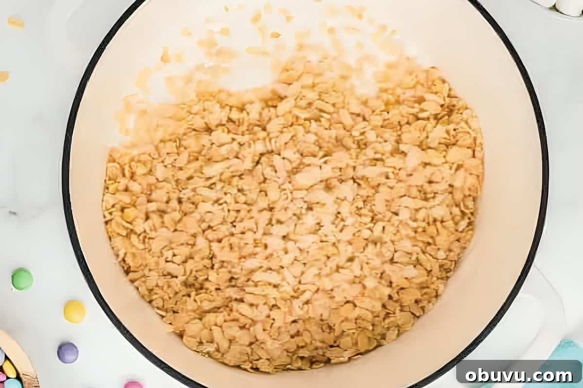 Easter Rice Krispie Treats Recipe with Colorful Spring Decorations 8 Rice Krispies cereal added to a pot of melted marshmallows.