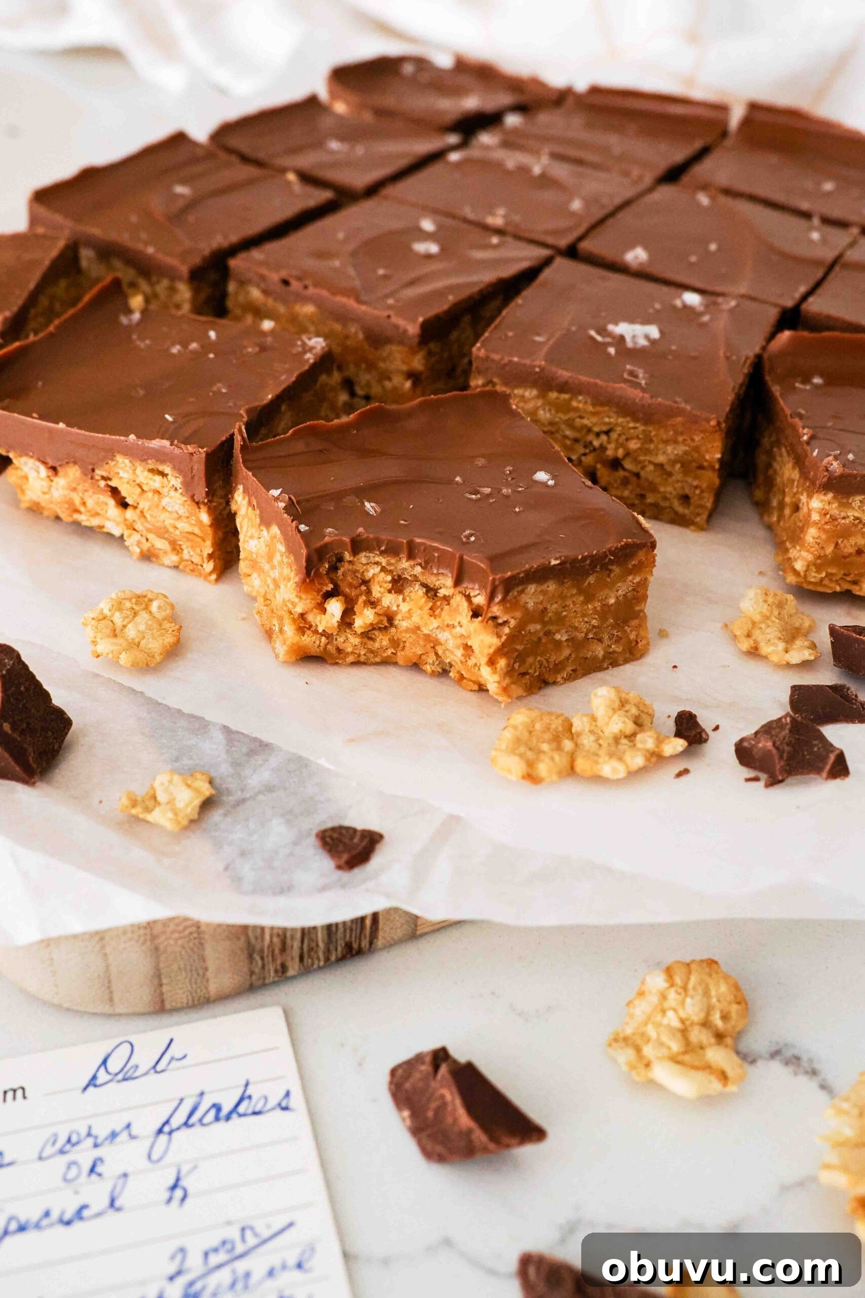 Aunt Deb’s Special K Bars Recipe — Crispy Cereal Treats 10 A bite is missing out of one Special K bar, with a handwritten recipe card nearby.