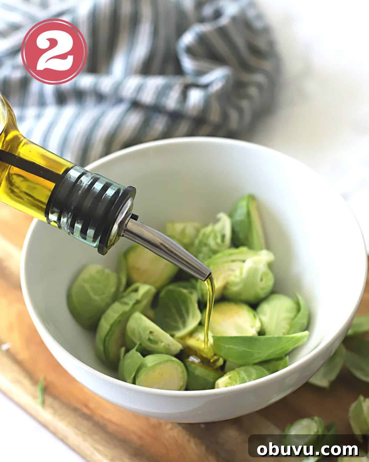 Crispy Oven-Roasted Brussels Sprouts with Balsamic Glaze 7 Brussels in a white bowls with olive oil being poured over them.