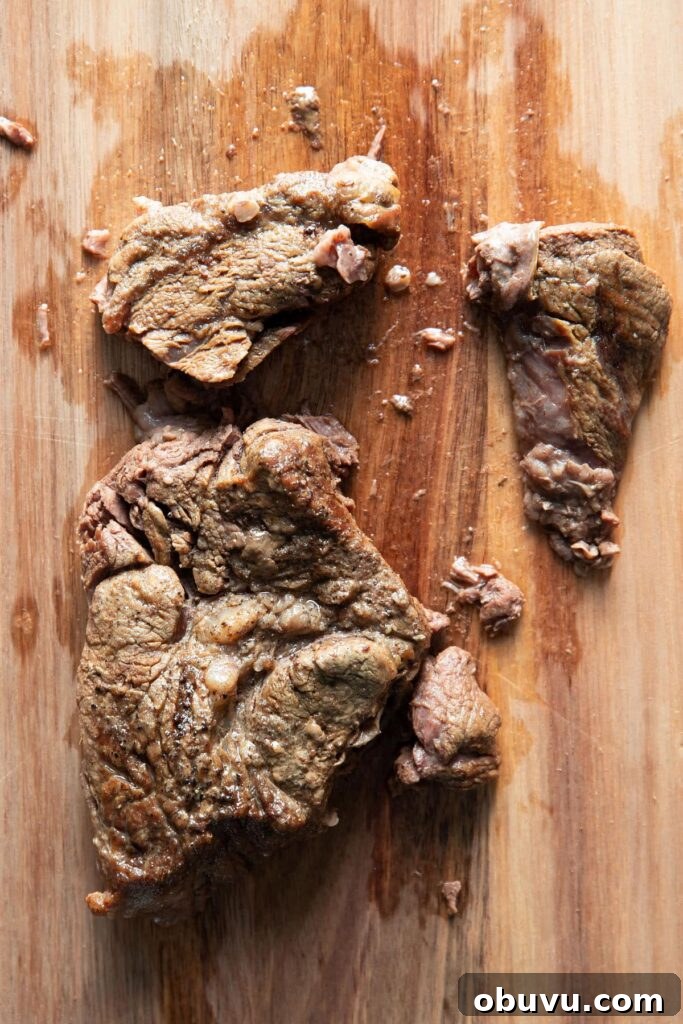 piece of pot roast on a cutting board that was cooked in an instant pot