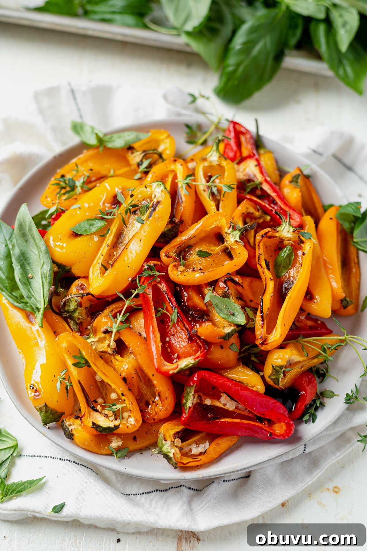Garlic-Roasted Mini Peppers: Flavorful Oven-Roasted Snack or Side 2 Close-up of roasted mini peppers with charred edges on a white plate.