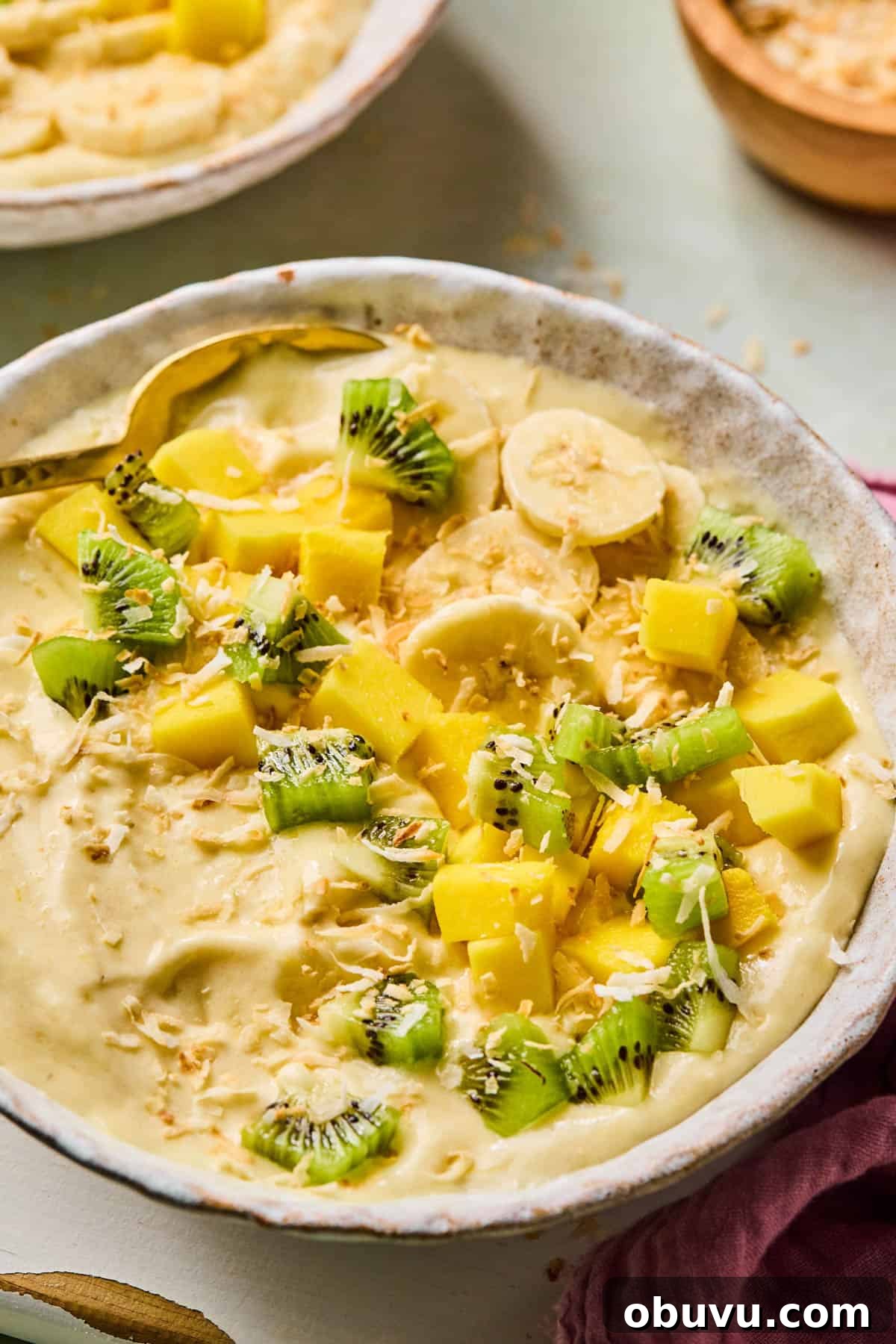Garlic-Roasted Mini Peppers: Flavorful Oven-Roasted Snack or Side 6 spoon dipped into a coconut smoothie bowl topped with kiwi, banana, and mango slices