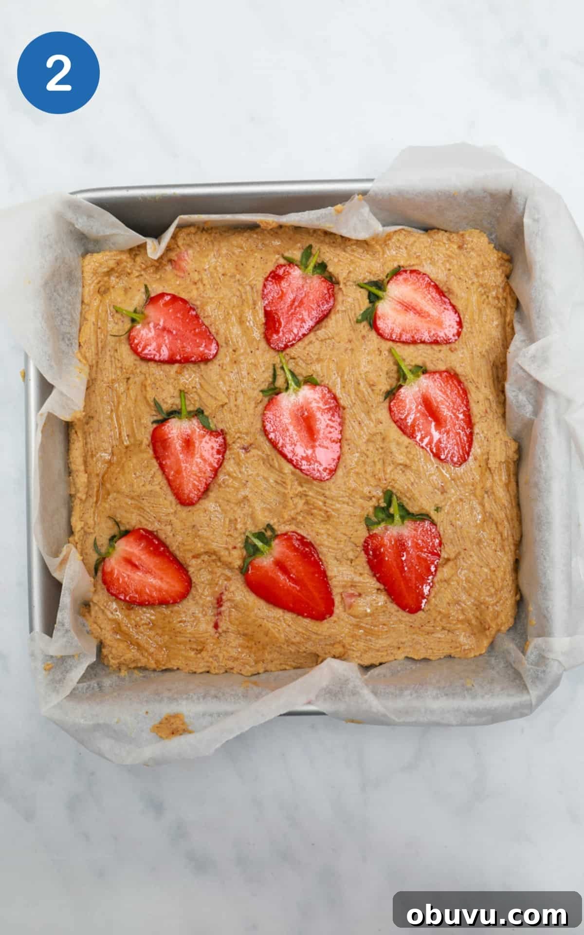 Chewy Peanut Butter Blondies Recipe for Rich, Gooey Bars 5 Peanut Butter Blondies mixture in a baking tray with strawberries on top.