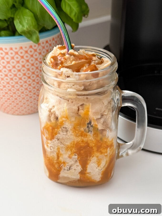 Ninja Creami Coffee Frappe Recipe: Creamy Iced Coffee Dessert 4 Ninja Creami Coffee Frappe served in a Milkshake glass drizzled with caramel sauce and a straw popped in the top.