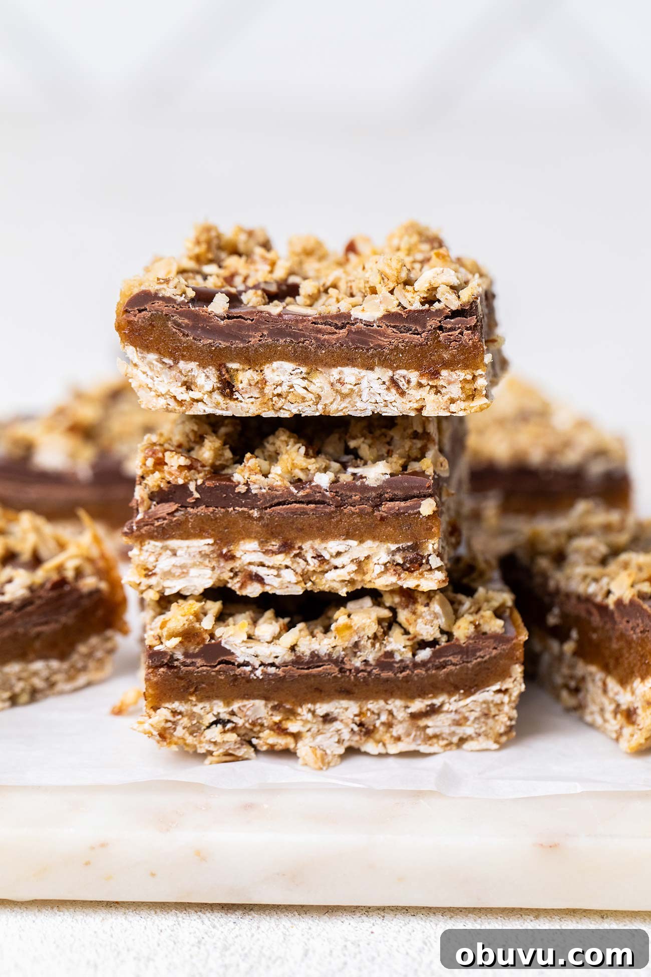 A stack of chocolate date bars on a marble cutting board.