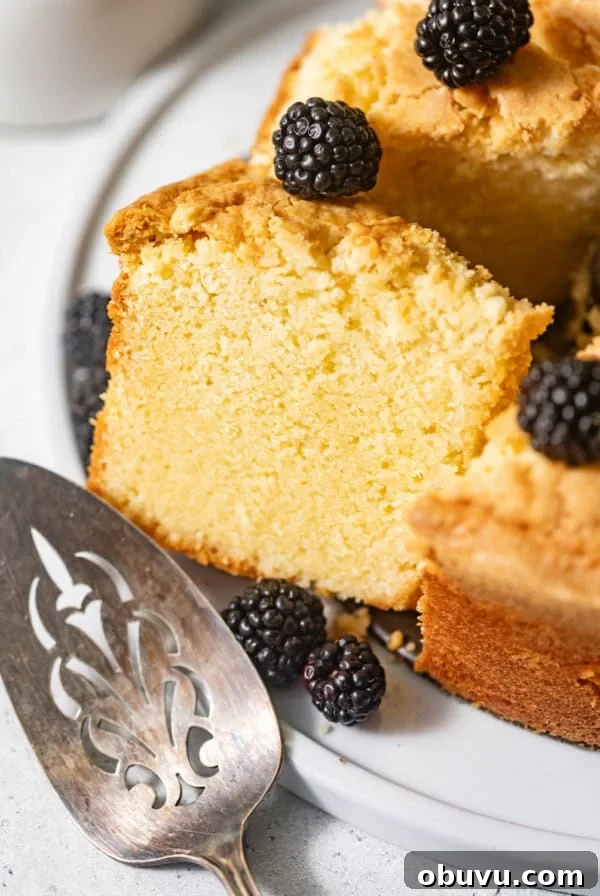 creme fraiche pound cake on a white plate with fresh blackberries on top.