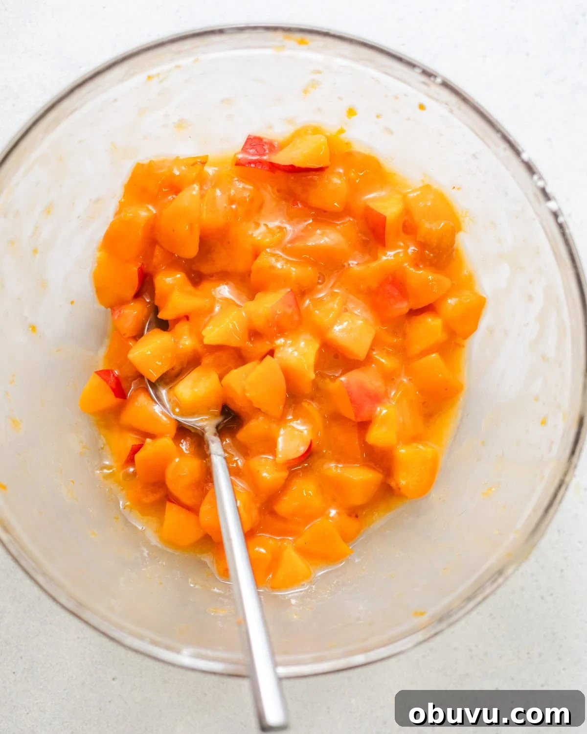 chopped apricots in a bowl tossed in cornstarch and apricot jam.
