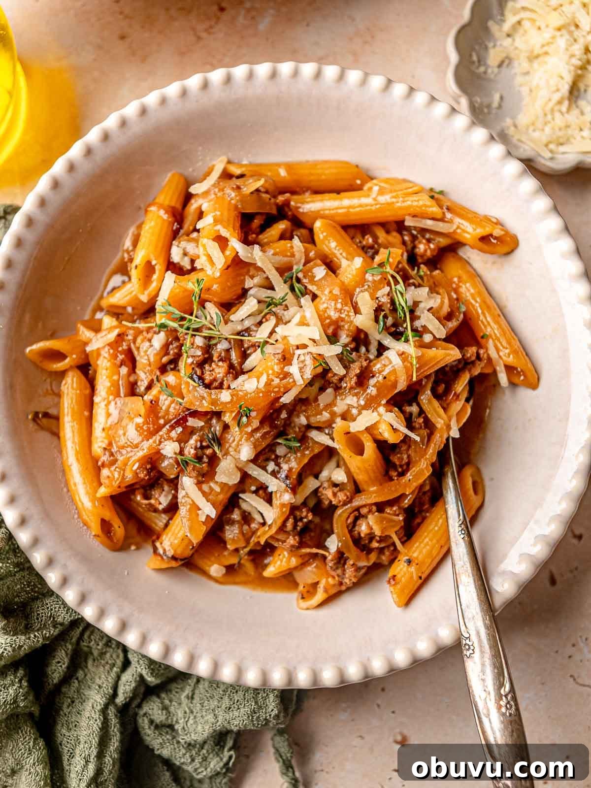 Creamy French Onion Soup Pasta Made in One Pot 4 A bowl of French onion soup pasta topped with parmesan cheese.
