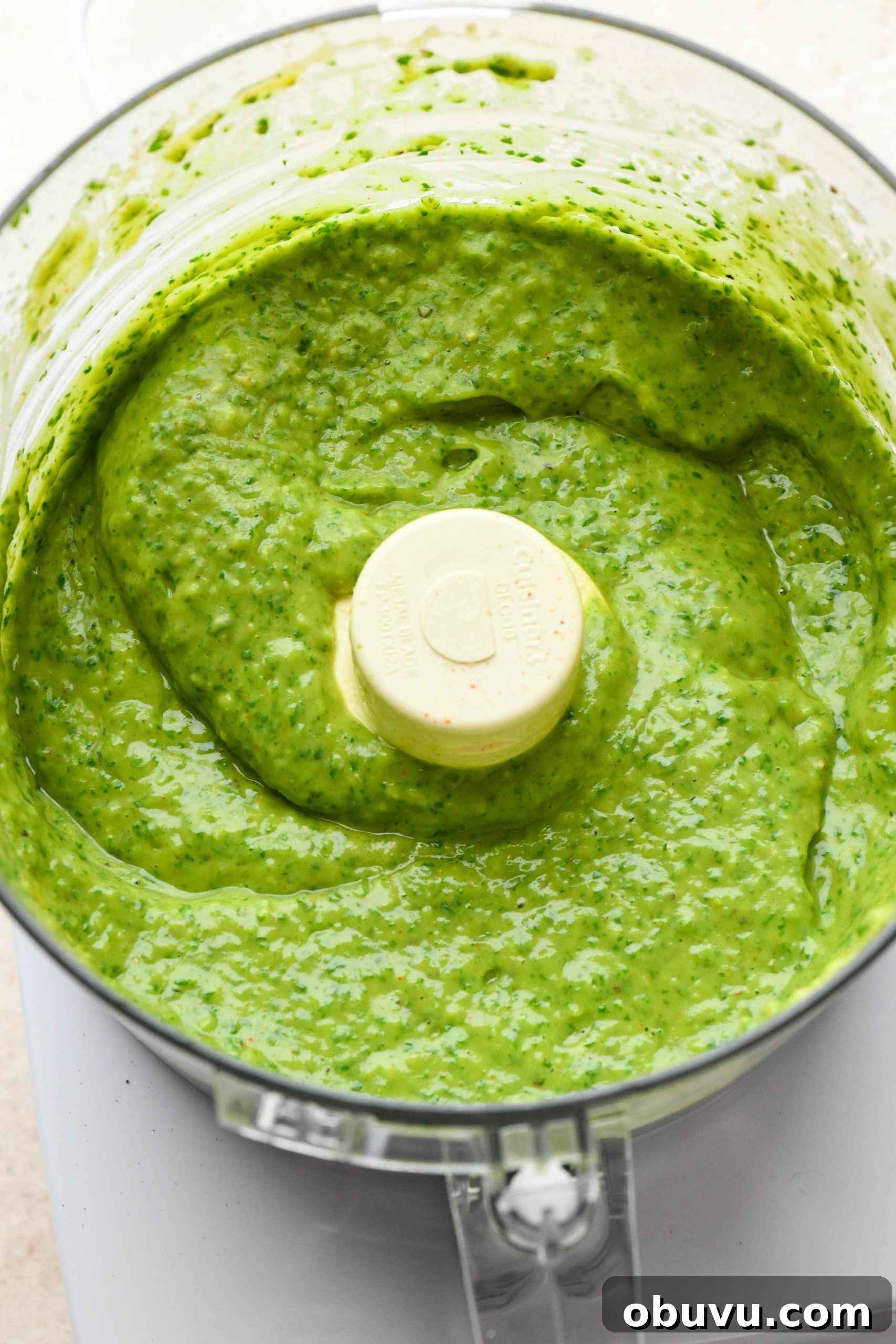 How to make avocado herb green sauce: Sauce processed together in the bowl of a food processor. 