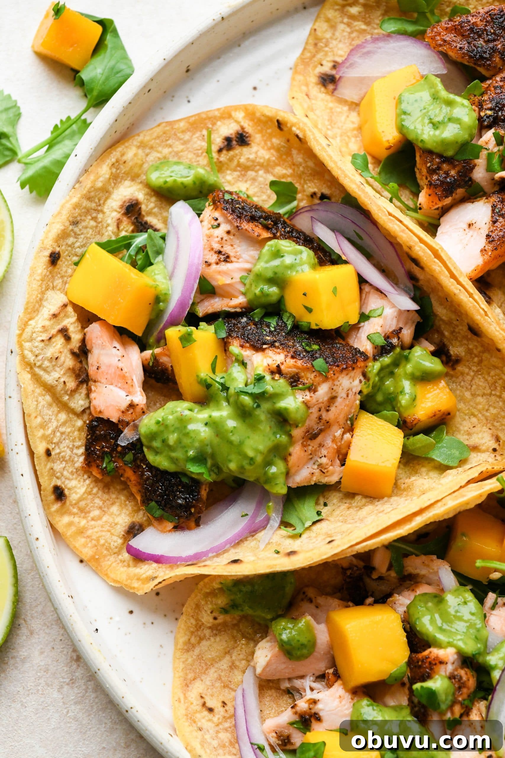 Blackened salmon tacos with avocado herb green sauce.