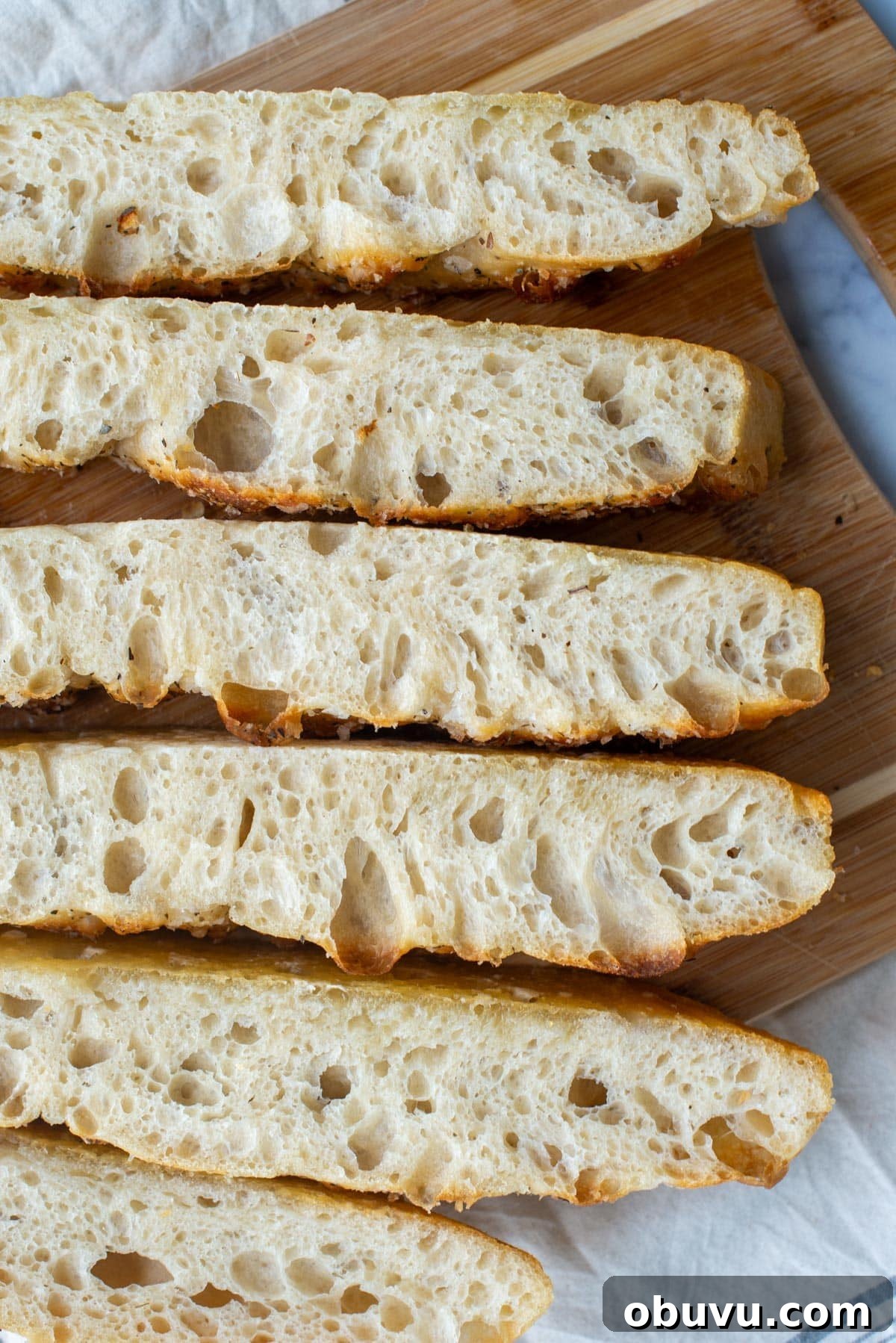 Sourdough Focaccia: Crispy, Airy Italian-Style Loaf Recipe 11 Slices of sourdough focaccia bread on a cutting board.