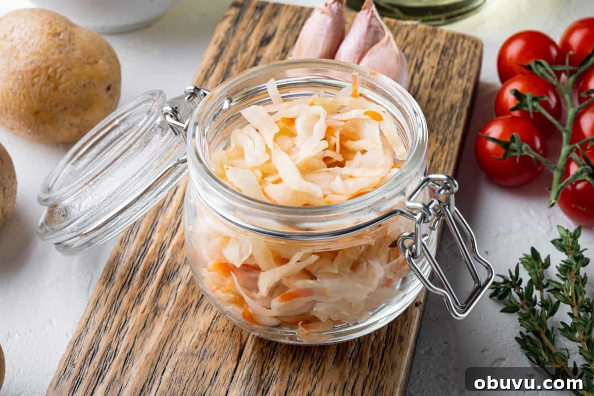 10 Essential Fermenting Supplies Every Home Preserver Needs 5 Sauerkraut in a glass jar with tomatoes and potatoes.