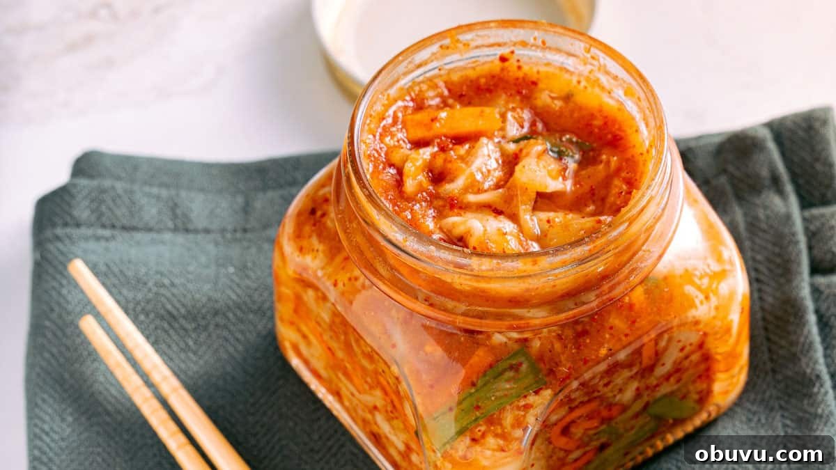 10 Essential Fermenting Supplies Every Home Preserver Needs 3 A jar of kimchi with chopsticks on a table.