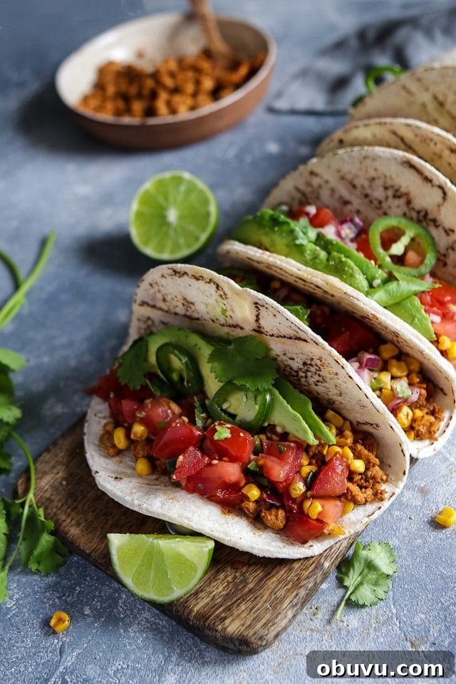 Vegan Tempeh Tacos with Savory Meat Filling 2 Vegan Tempeh Tacos with Corn and Tomatoes on a Wooden Board