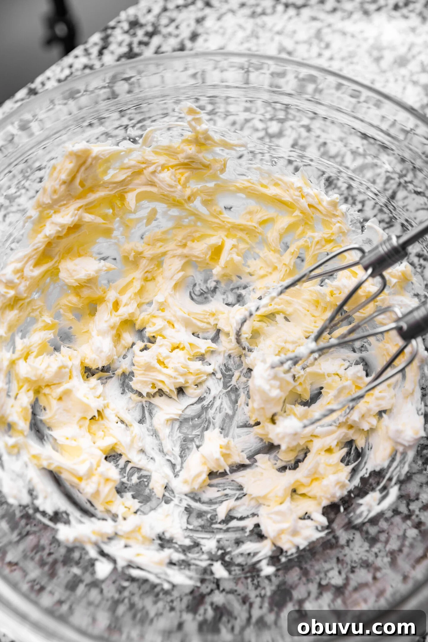Freeze-Dried Strawberry Cream Cheese Frosting Recipe 4 Cream cheese and butter being beaten together in a glass mixing bowl.