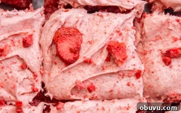 Freeze-Dried Strawberry Cream Cheese Frosting Recipe 7 Close up of strawberry cream cheese frosting on top of a cake with chopped freeze dried strawberries sprinkled on top.