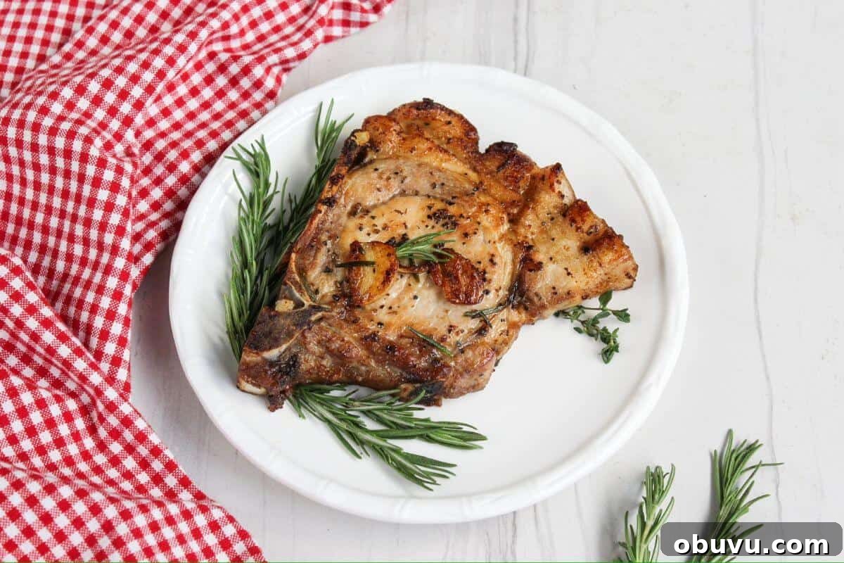 29 Delicious Low-Carb Meals That Aren’t Just Salad 15 Pork chops on a plate with rosemary sprigs.