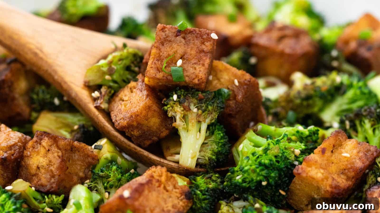 29 Delicious Low-Carb Meals That Aren’t Just Salad 18 Roasted broccoli and tofu cubes garnished with sesame seeds and green onions, served with a wooden spoon.