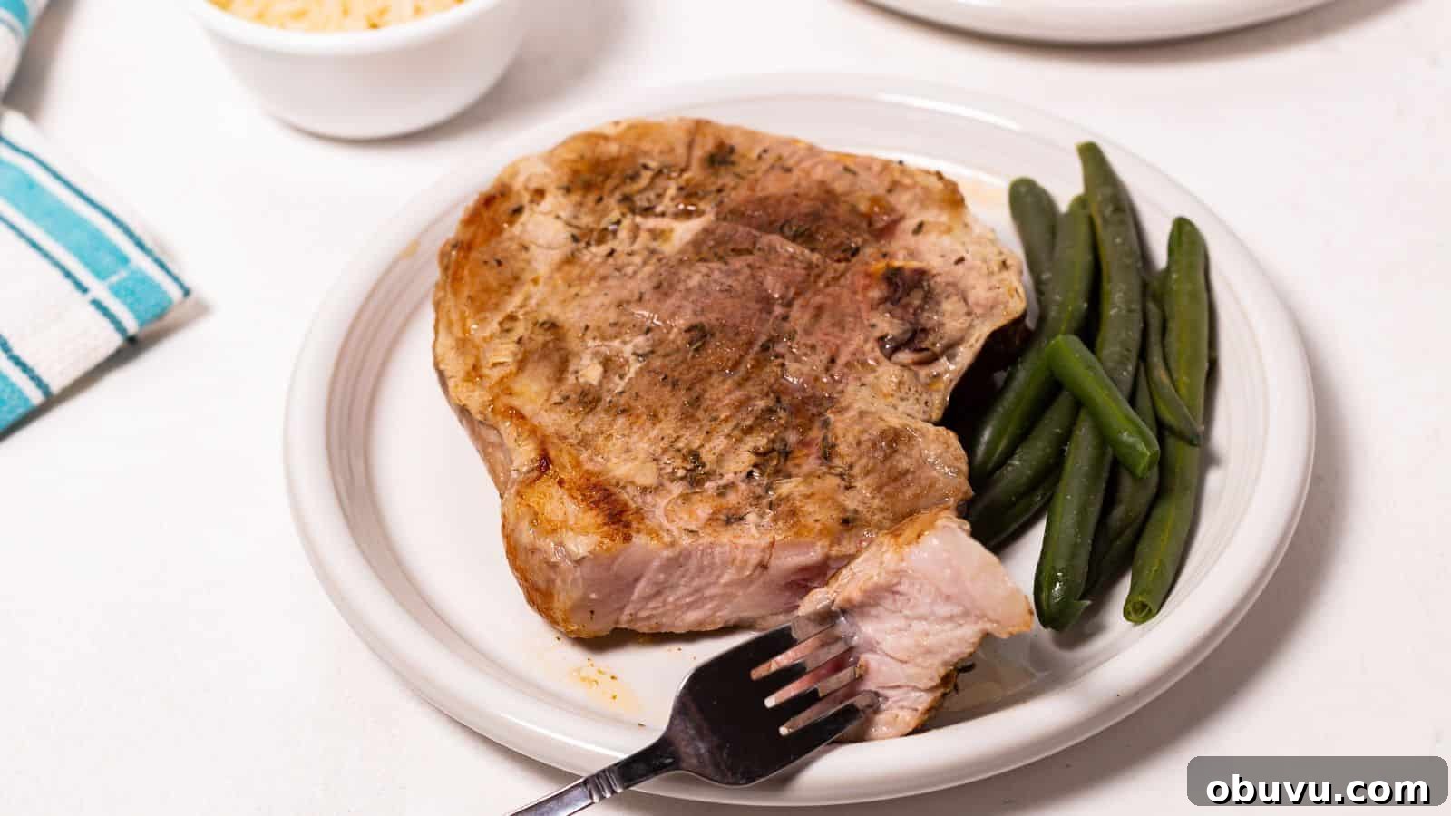 29 Delicious Low-Carb Meals That Aren’t Just Salad 20 Oven baked pork steak on a plate with green beans and a fork on the side.