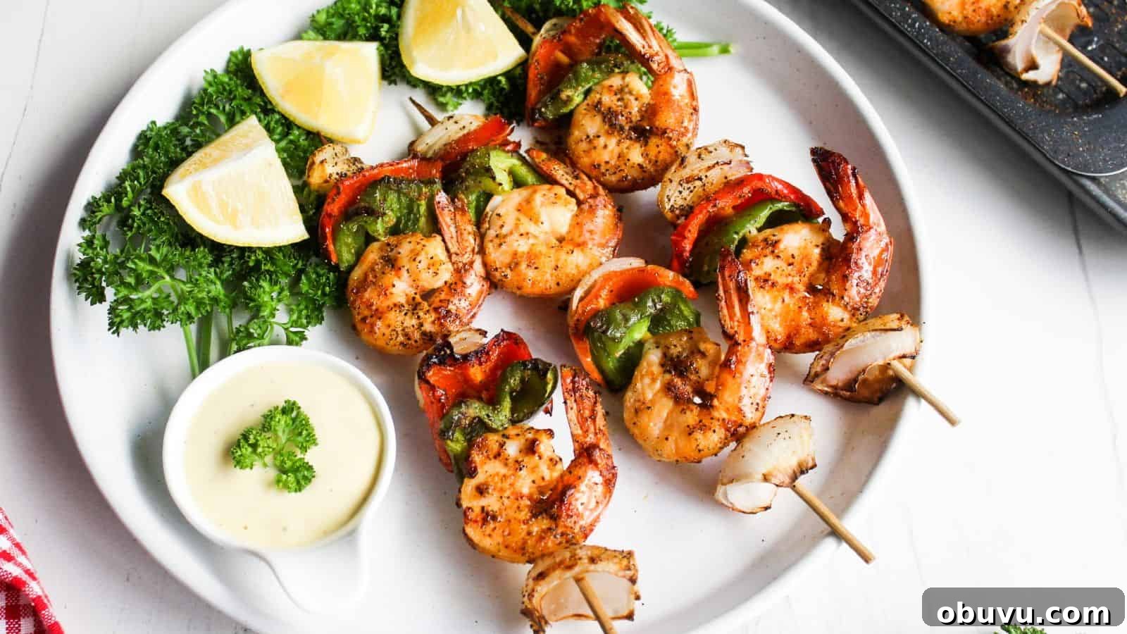 29 Delicious Low-Carb Meals That Aren’t Just Salad 21 Grilled shrimp skewers with red and green bell peppers, served with lemon wedges and a dipping sauce on a white plate.
