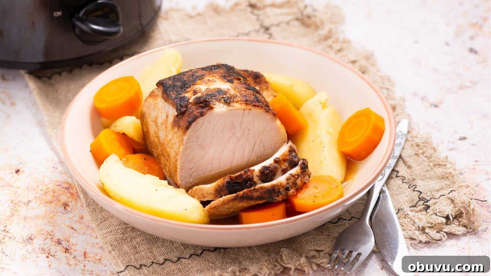 29 Delicious Low-Carb Meals That Aren’t Just Salad 31 A plate with roasted pork, sliced carrots, and potatoes on a woven mat, with a fork and knife beside the dish. A slow cooker is partially visible in the background.