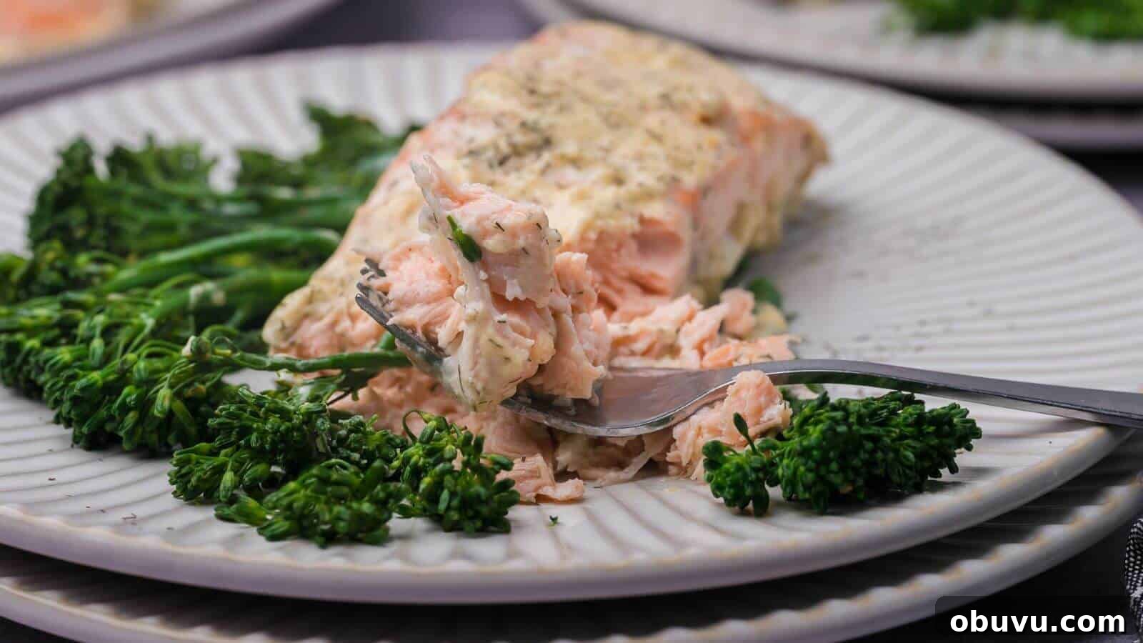 29 Delicious Low-Carb Meals That Aren’t Just Salad 7 A plated piece of seasoned salmon with a portion removed on a fork, served alongside steamed broccolini.