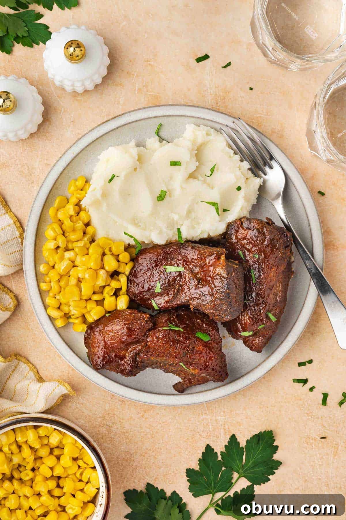 Tender Country-Style Ribs in the Slow Cooker: Simple Recipe 8 Overhead view of a plate of slow cooker country style ribs, mashed potatoes, and corn with a fork.