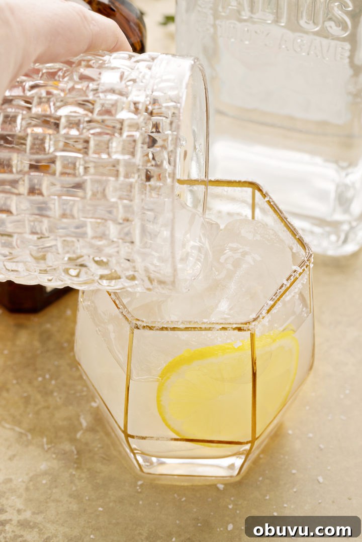 photo of a lemon tequila cocktail being poured into a salt rimmed glass