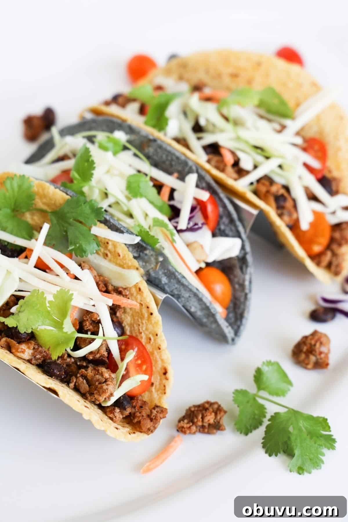 Savory Ground Turkey Tacos with Quick Homemade Seasoning 2 Three ground turkey tacos in a taco holder on white platter.