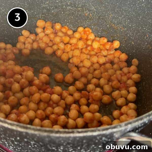 sauteeing the chickpeas in the garlic and tomato paste