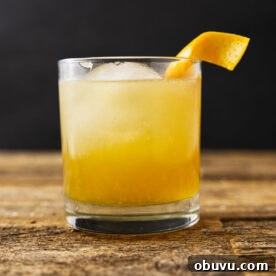 Maple Bourbon Smash Cocktail Recipe — Warm Autumn Whiskey Smash 14 Close up of a maple bourbon smash with an orange peel twist hanging on the rim.
