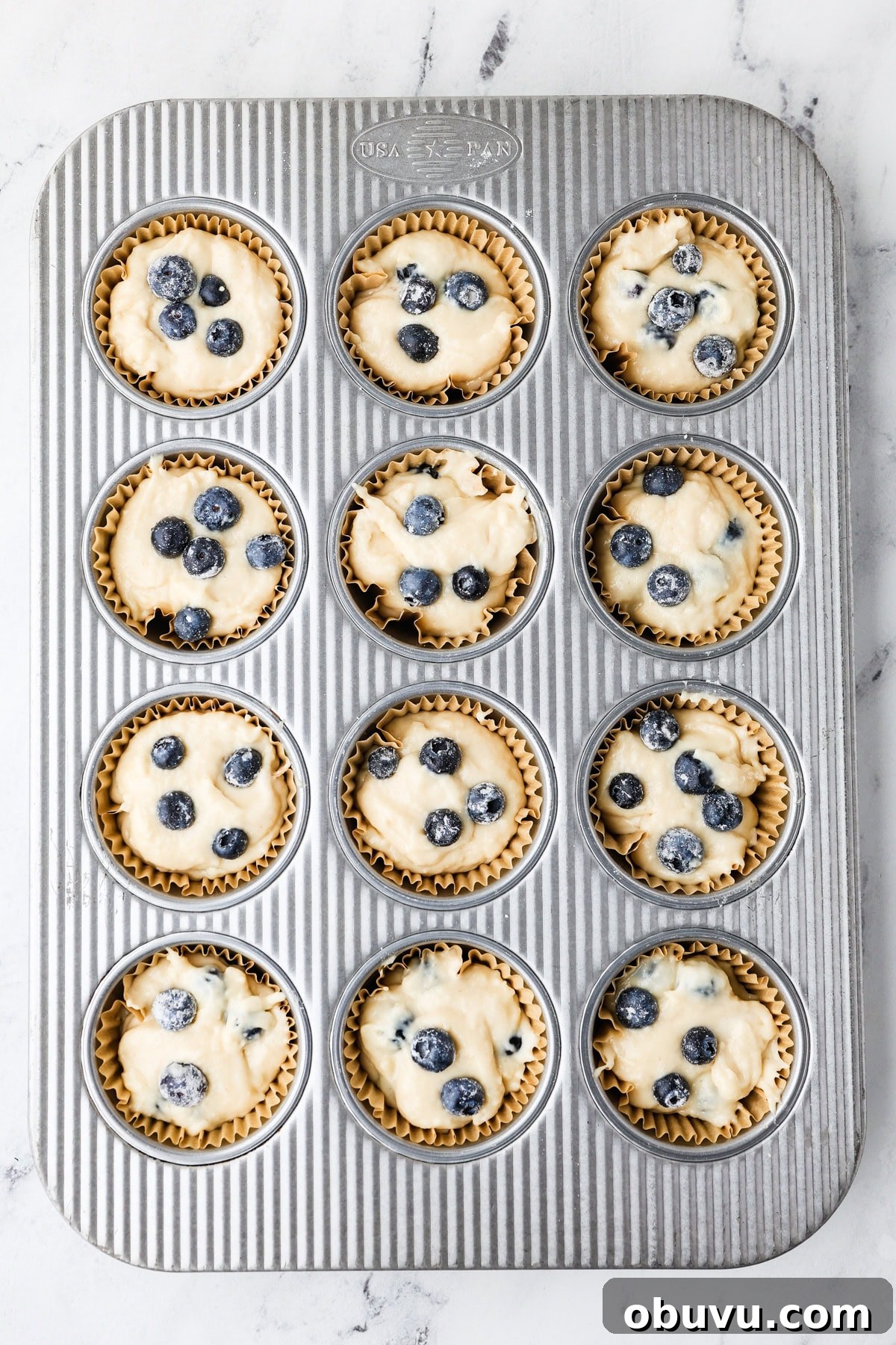 An overhead image of transferring the mixture in a muffin tin.