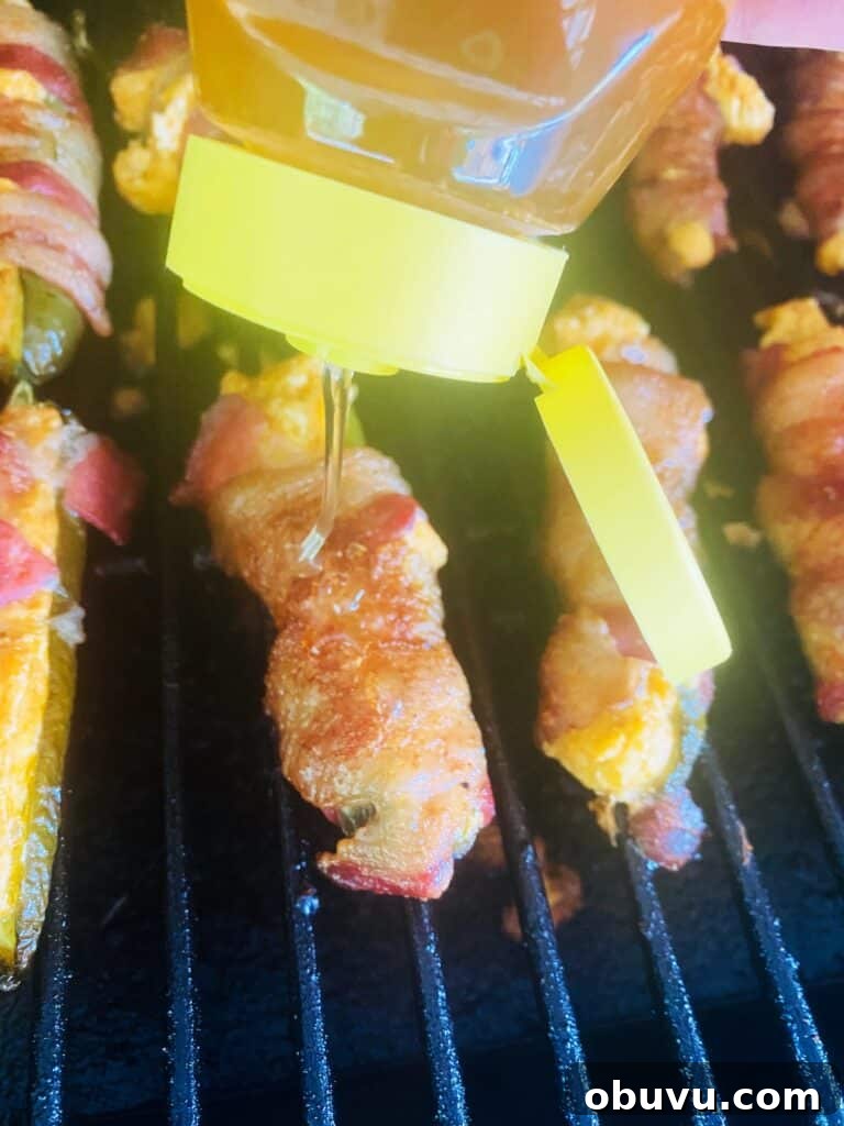 Smoked Honey Jalapeño Poppers with Creamy Cheese Filling 9 drizzling honey over Smoked Honey Hot Jalapeno Poppers