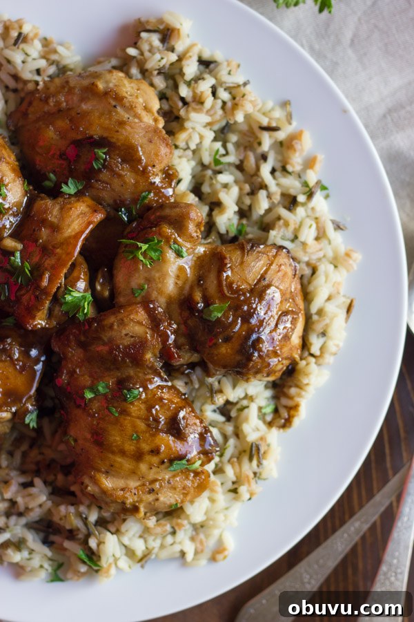 Creamy Balsamic Skillet Chicken served over rice on a plate.