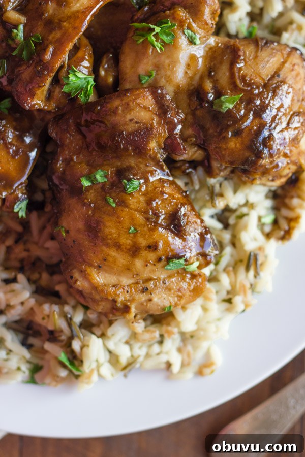 Creamy Balsamic Skillet Chicken served over rice on a plate.