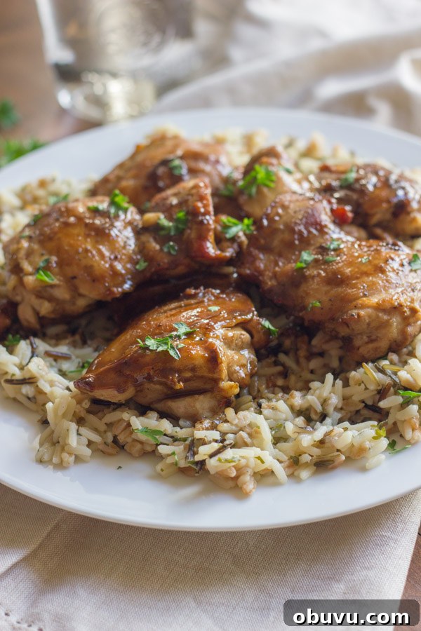 Creamy Balsamic Skillet Chicken served over rice on a plate.