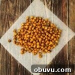 Crispy air fryer chickpeas on white paper on a wooden table.