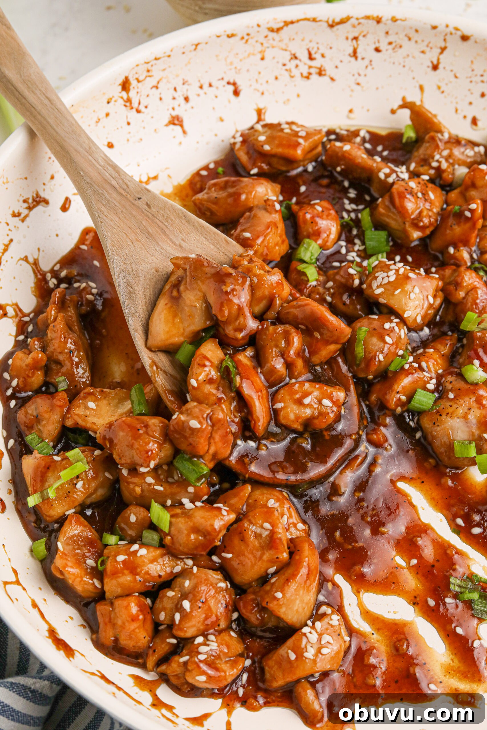 30-Minute Bourbon Chicken Skillet Recipe That Beats Takeout 24 Bourbon Chicken close up in a skillet with a spoon scooping some up