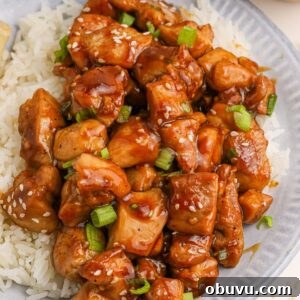30-Minute Bourbon Chicken Skillet Recipe That Beats Takeout 25 Bourbon Chicken piled on top of a plate with some rice on the side and topped with sesame seeds and green onions