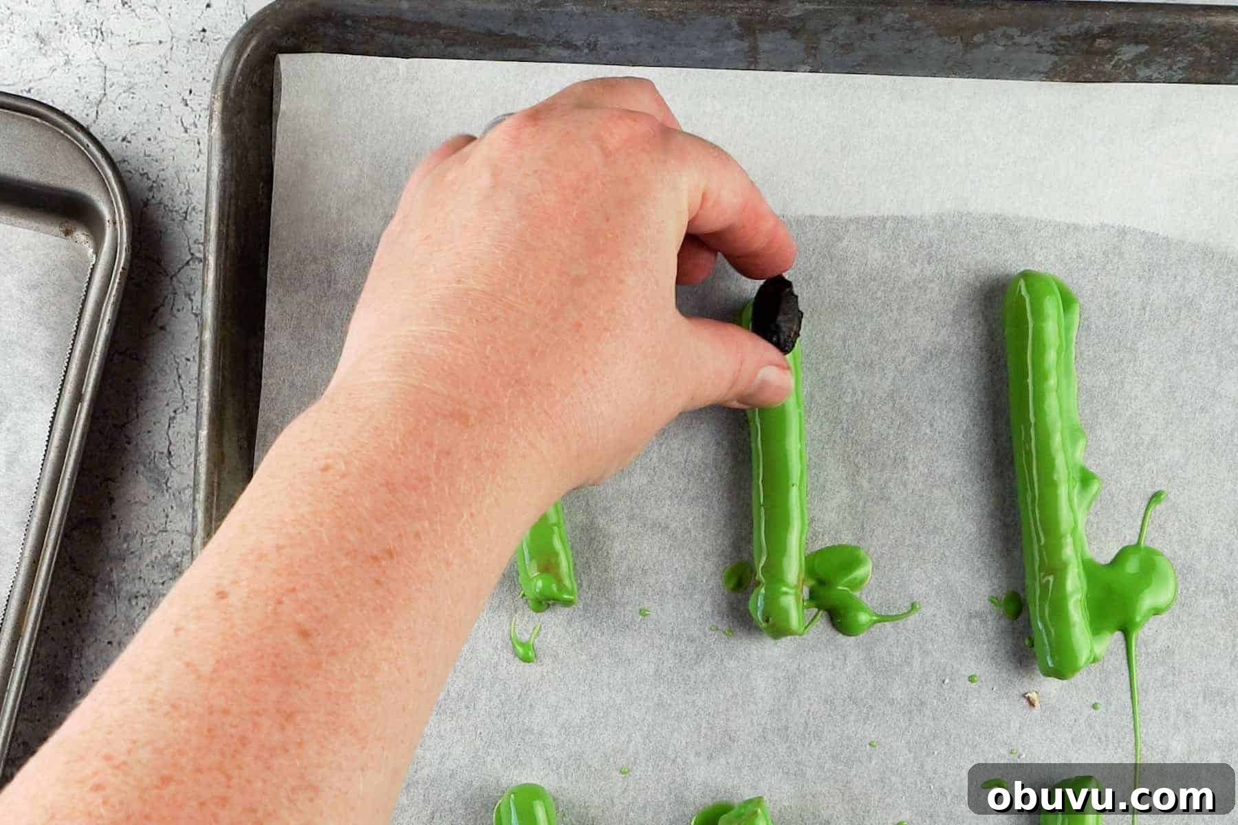 Witch Finger Cookies Recipe: Spooky Halloween Treats 7 adding an almond to a candy dipped pretzel rod.
