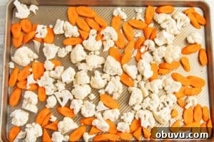 Roasted Carrots and Cauliflower in Cheesy Garlic Crust 12 This is a picture of a baking tray with raw carrots and cauliflower.