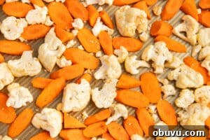 Roasted Carrots and Cauliflower in Cheesy Garlic Crust 13 This is a picture of a baking tray with seasoned carrots and cauliflower.