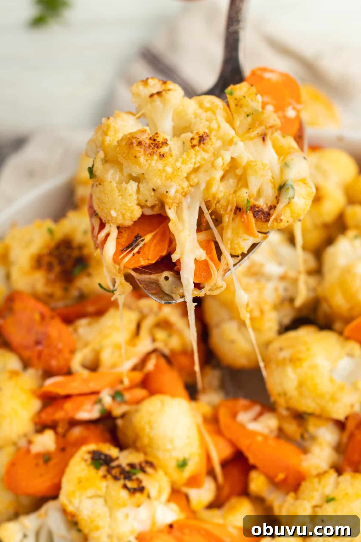 Roasted Carrots and Cauliflower in Cheesy Garlic Crust 3 This is a picture of a spoon filled with cheesy roasted veggies.